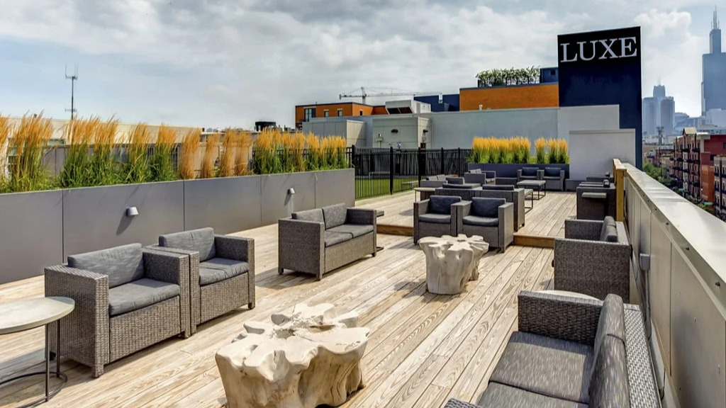 Rooftop lounge at Luxe on Madison Apartments in Chicago with modern outdoor seating and panoramic city skyline views