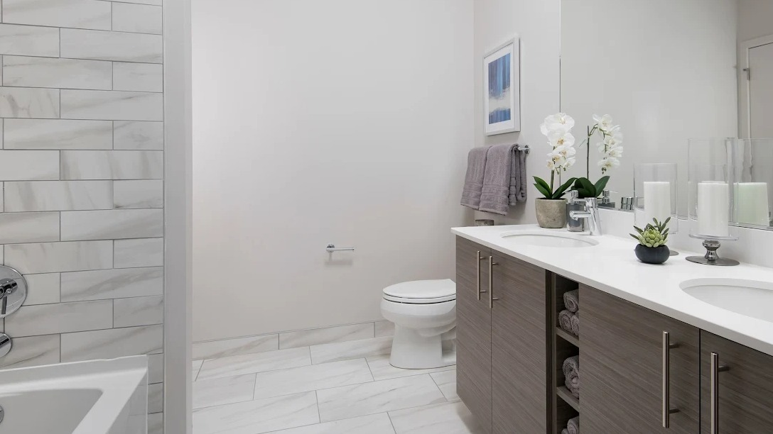 Spacious modern bathroom with a double vanity, large mirror, and a sleek shower-tub combination at Luxe on Madison Apartments in Chicago