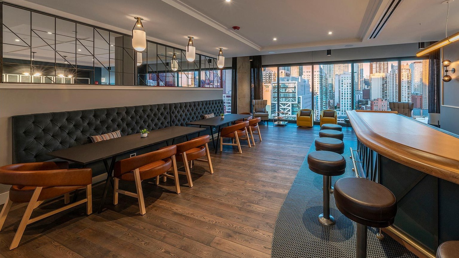Sophisticated bar and lounge area with ample seating, modern lighting, and expansive city views, perfect for entertaining at Marlowe Apartments in Chicago