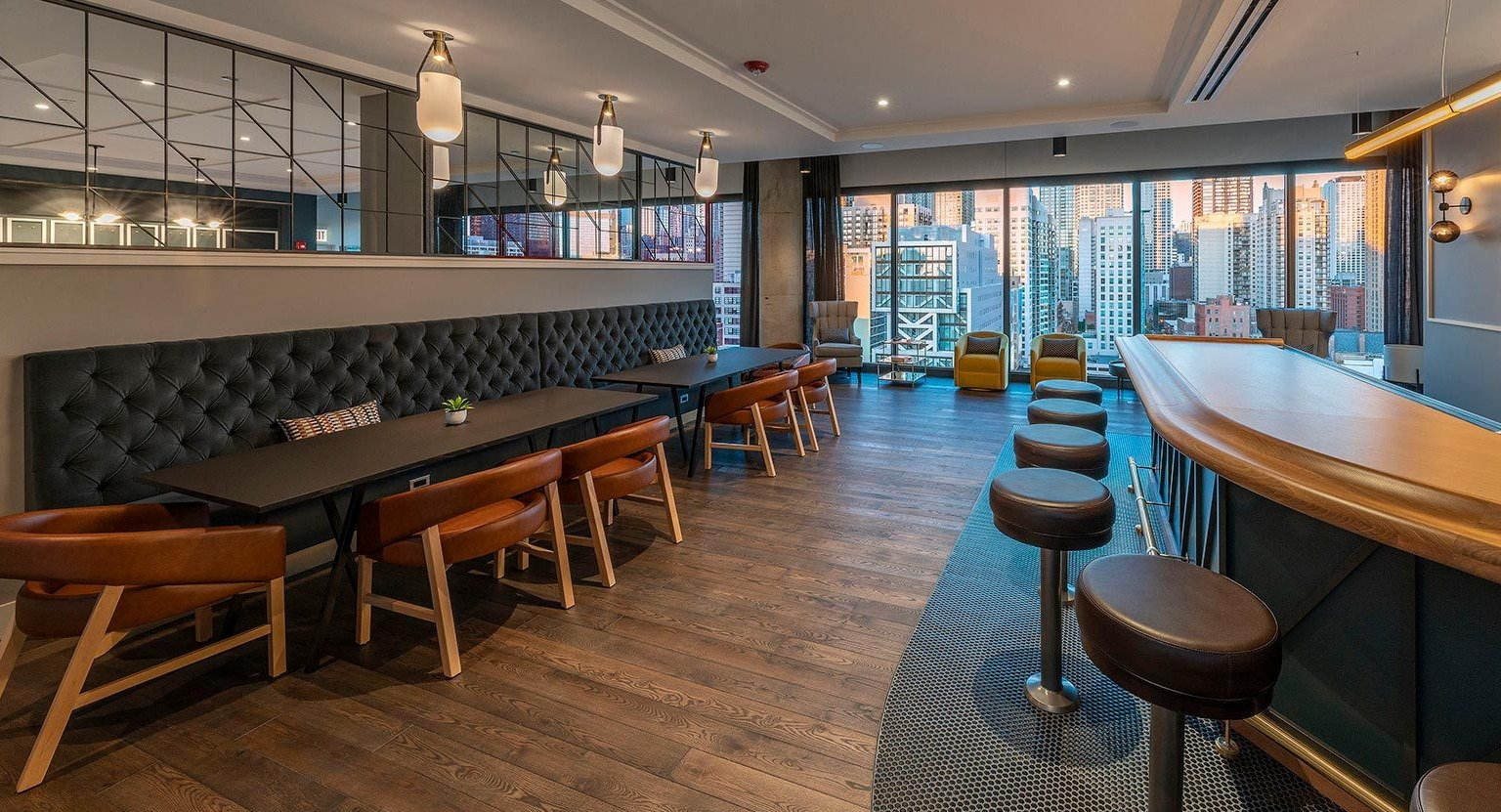 Sophisticated bar and lounge area with ample seating, modern lighting, and expansive city views, perfect for entertaining at Marlowe Apartments in Chicago