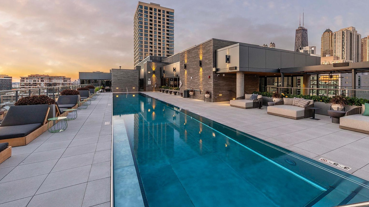 Luxurious rooftop swimming pool surrounded by lounge seating, offering breathtaking skyline views at Marlowe Apartments in Chicago