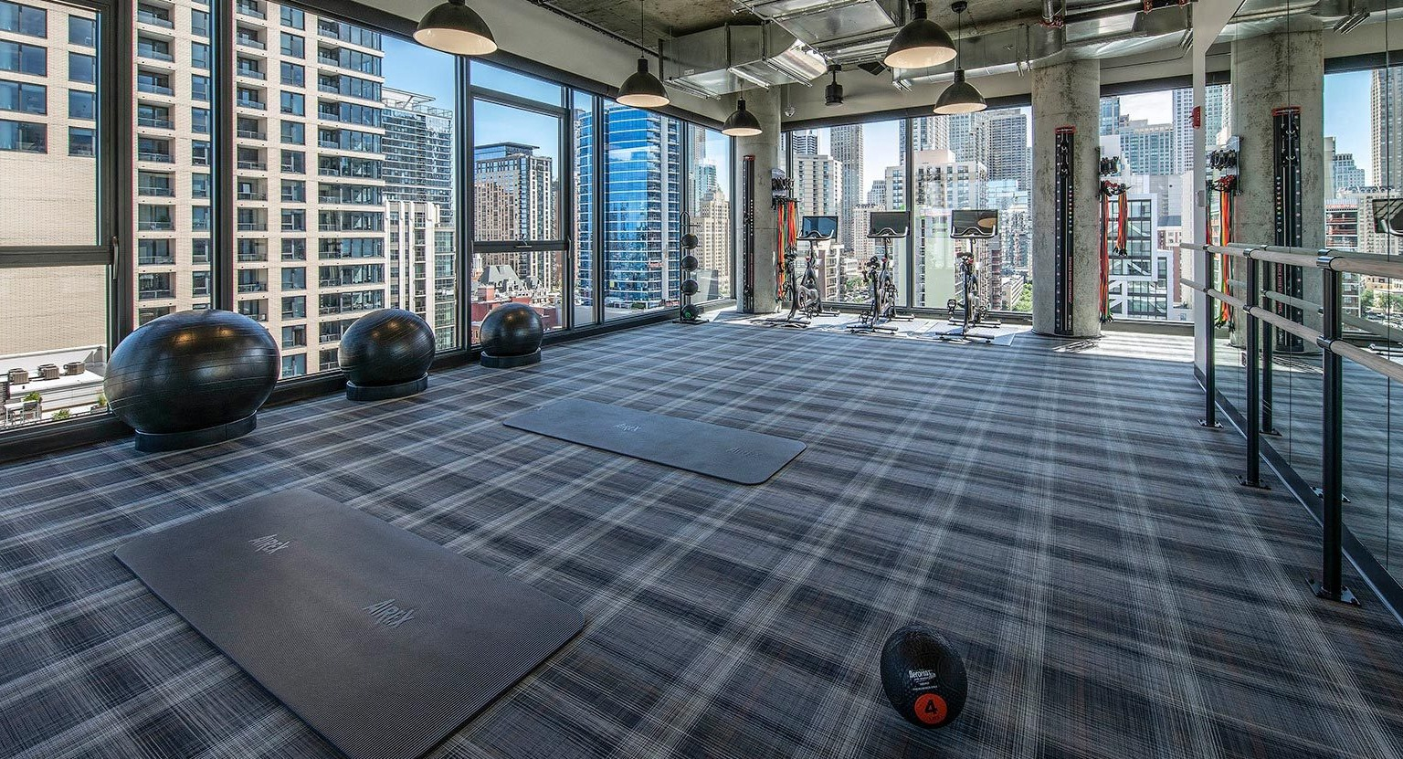 Spacious yoga and fitness studio with exercise balls, mats, and large windows providing abundant natural light and city views at Marlowe Apartments in Chicago