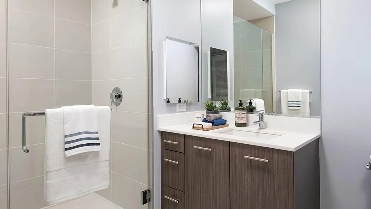 Modern bathroom featuring a spacious walk-in shower with glass enclosure and a stylish vanity at Marquee at Block 37 in Chicago