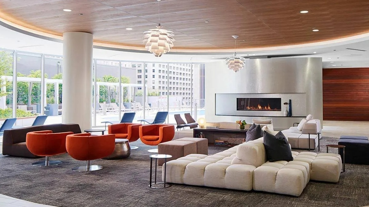 Expansive resident lounge with diverse seating arrangements, a modern fireplace, and large windows at Marquee at Block 37 in Chicago