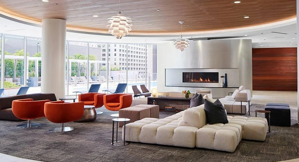 Expansive resident lounge with diverse seating arrangements, a modern fireplace, and large windows at Marquee at Block 37 in Chicago