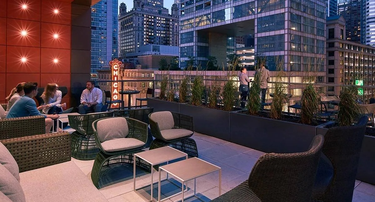 Residents relaxing on a modern rooftop lounge with comfortable seating and stunning city views at Marquee at Block 37 in Chicago