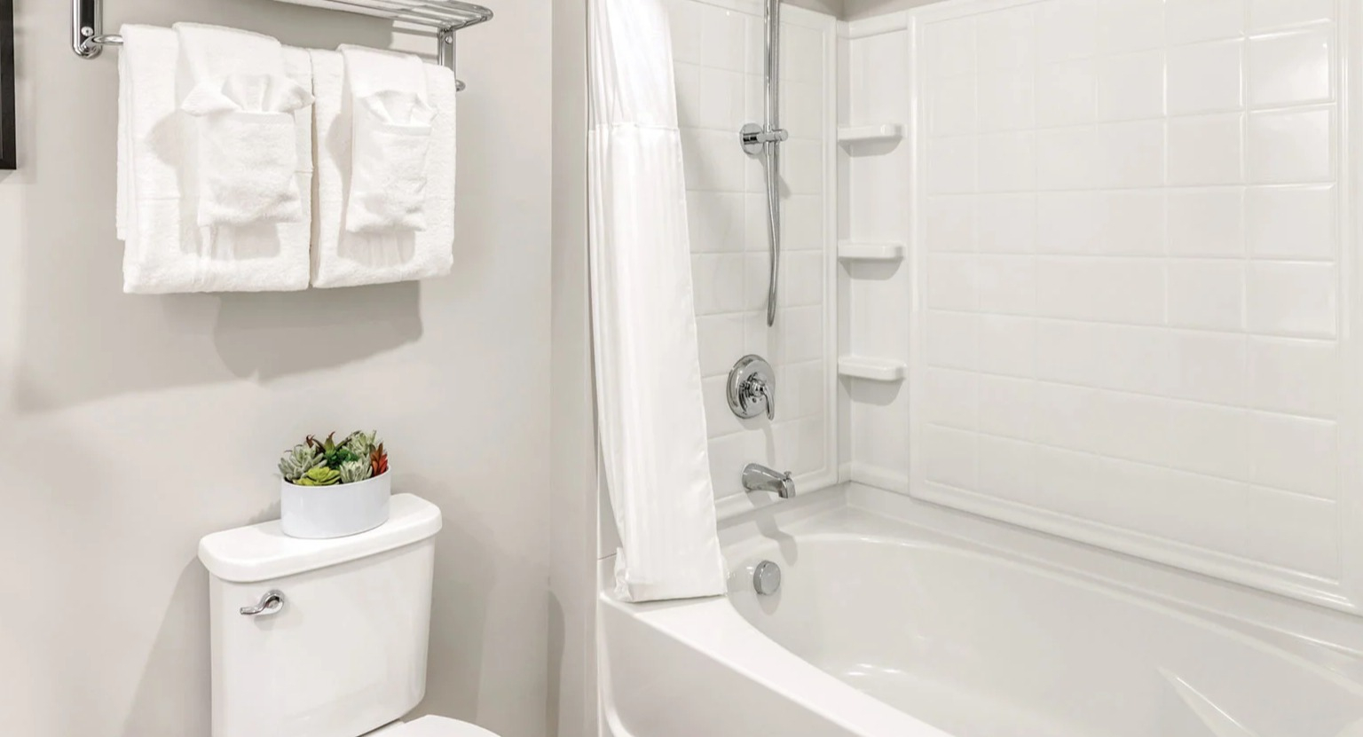 Clean and modern bathroom with a toilet, a shower-tub combination, and fresh towels at MDA Apartments in Chicago
