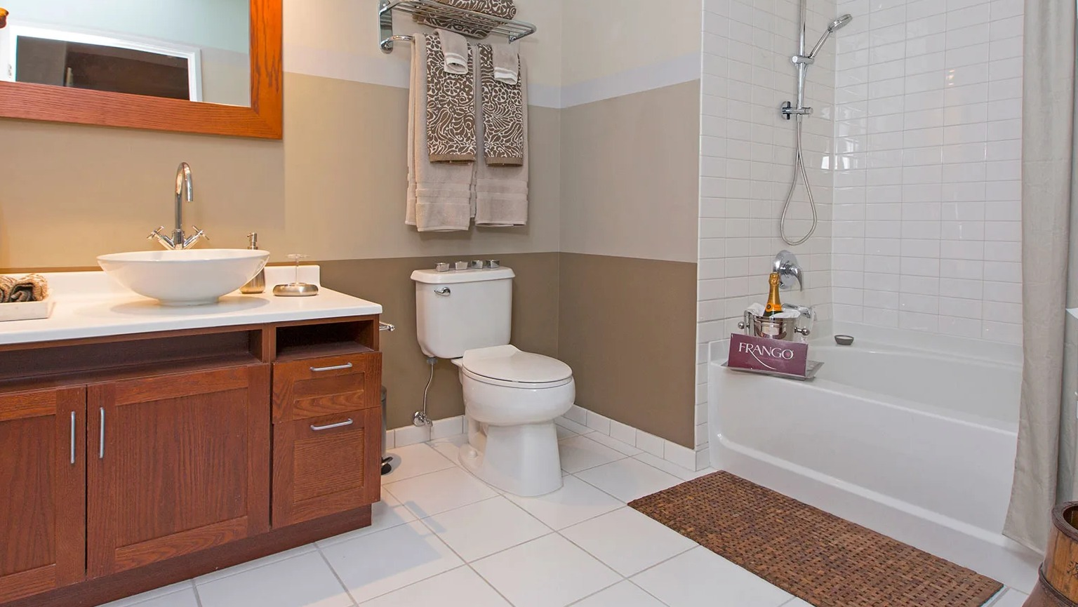 Stylish bathroom featuring a unique vessel sink vanity, a toilet, and a shower-tub combination at MDA Apartments in Chicago