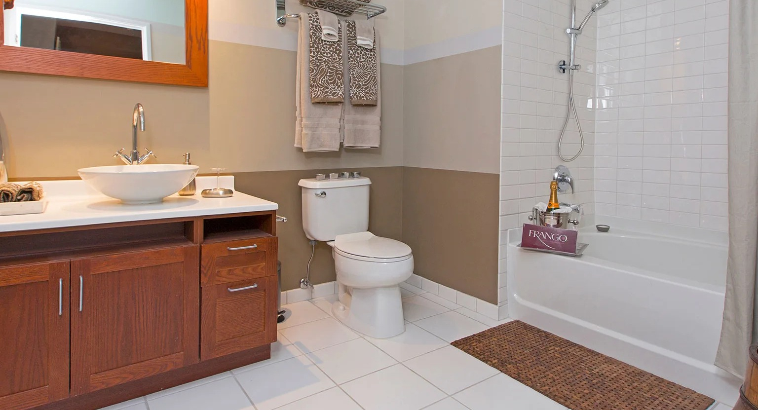 Stylish bathroom featuring a unique vessel sink vanity, a toilet, and a shower-tub combination at MDA Apartments in Chicago