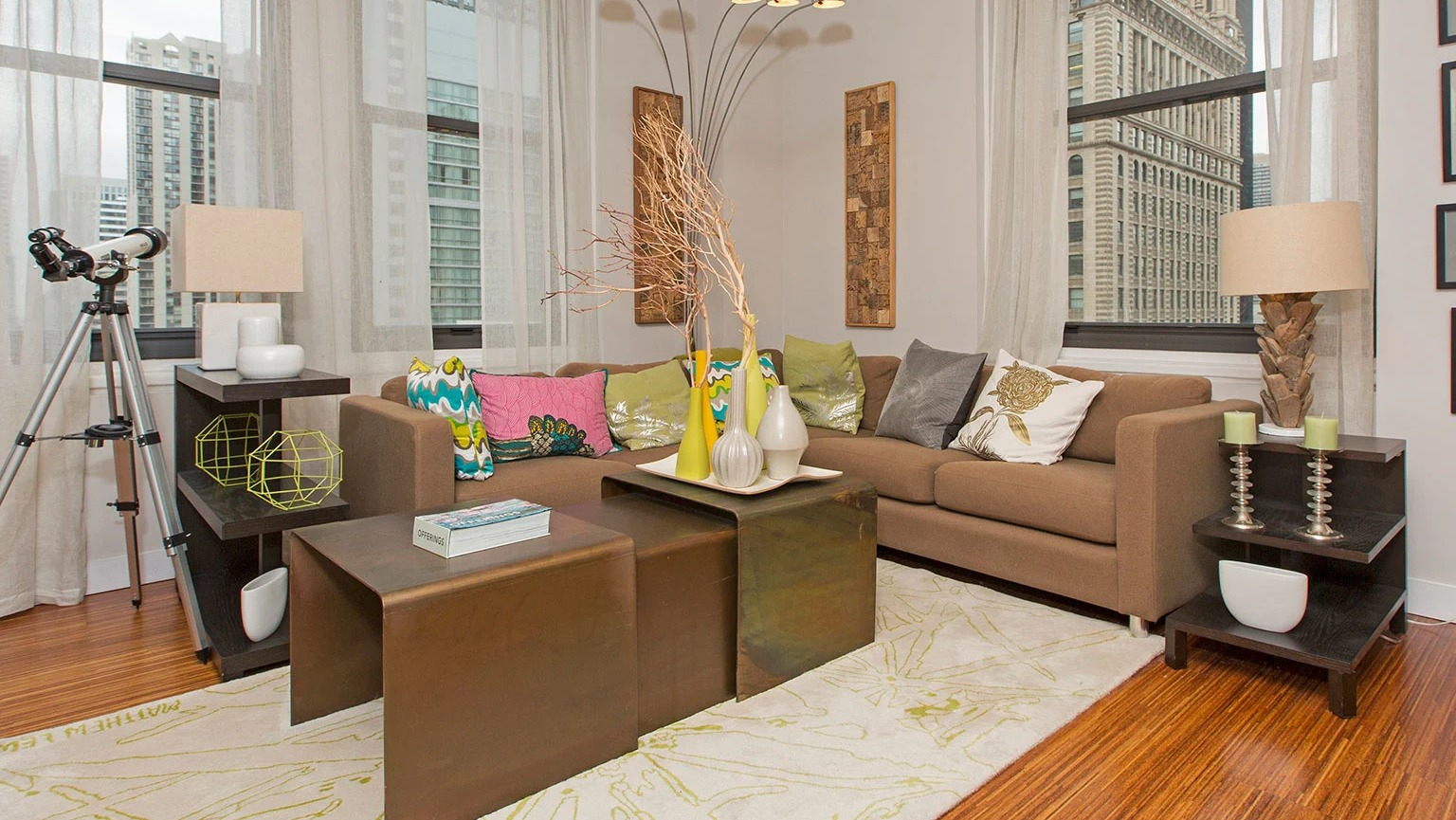 Bright living room with comfortable sofas, modern decor, and expansive windows offering city views at MDA Apartments in Chicago