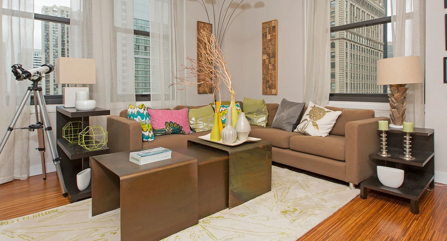Bright living room with comfortable sofas, modern decor, and expansive windows offering city views at MDA Apartments in Chicago