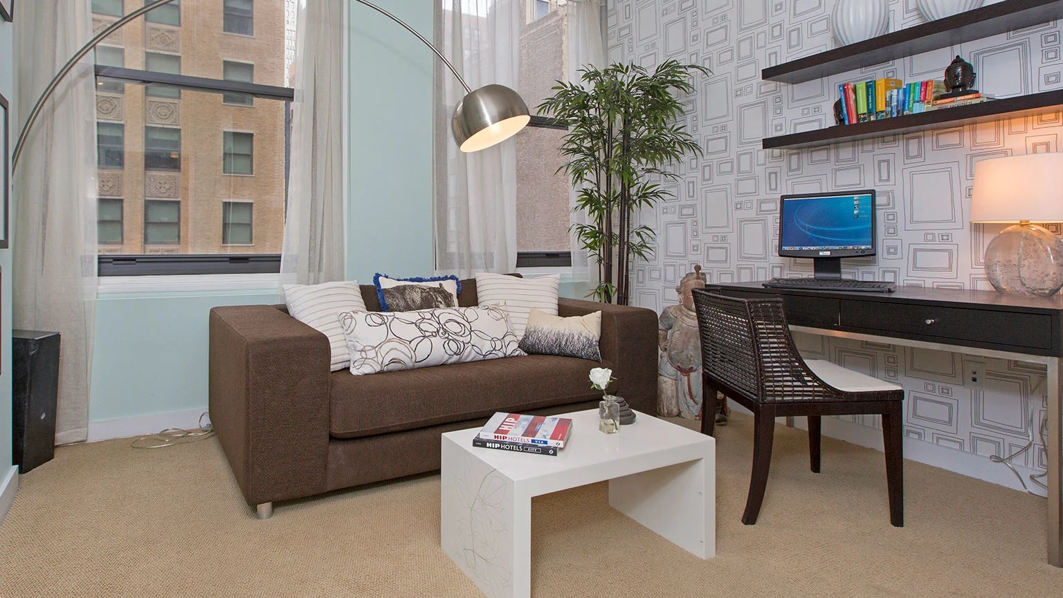 Contemporary living room with a comfortable sofa, a dedicated desk area, and large windows bringing in light at MDA Apartments in Chicago