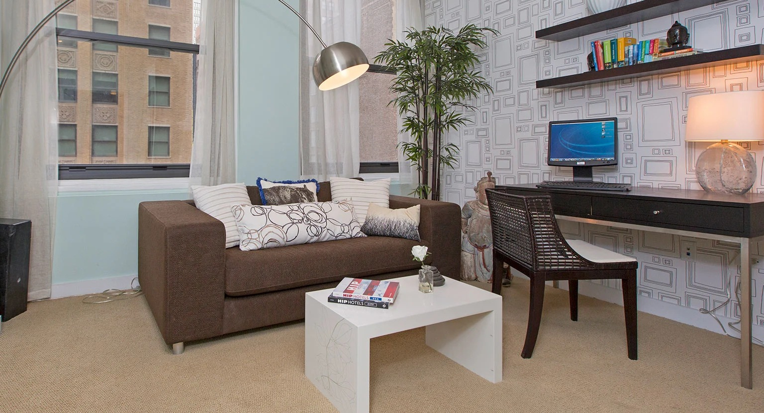 Contemporary living room with a comfortable sofa, a dedicated desk area, and large windows bringing in light at MDA Apartments in Chicago