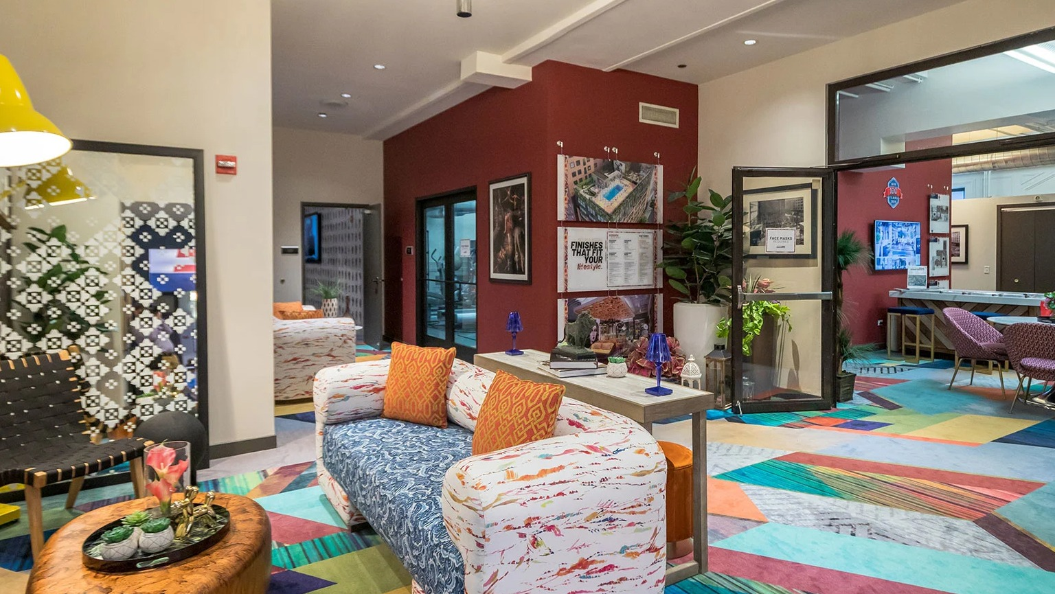 Vibrant and colorful resident lounge with diverse seating, modern lighting, and a lively atmosphere at MDA Apartments in Chicago