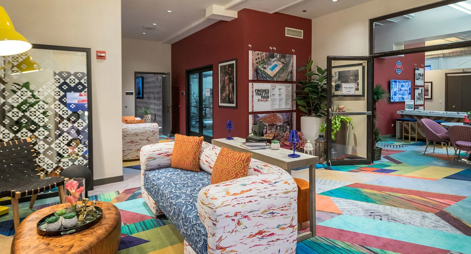 Vibrant and colorful resident lounge with diverse seating, modern lighting, and a lively atmosphere at MDA Apartments in Chicago