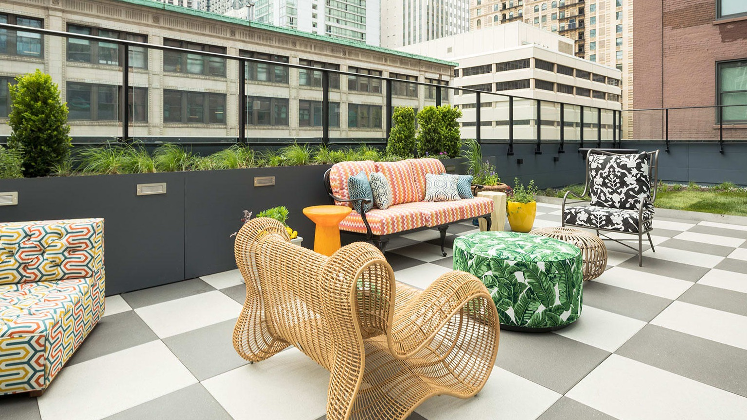 Stylish rooftop terrace with patterned seating and modern furniture, offering city views at MDA Apartments in Chicago