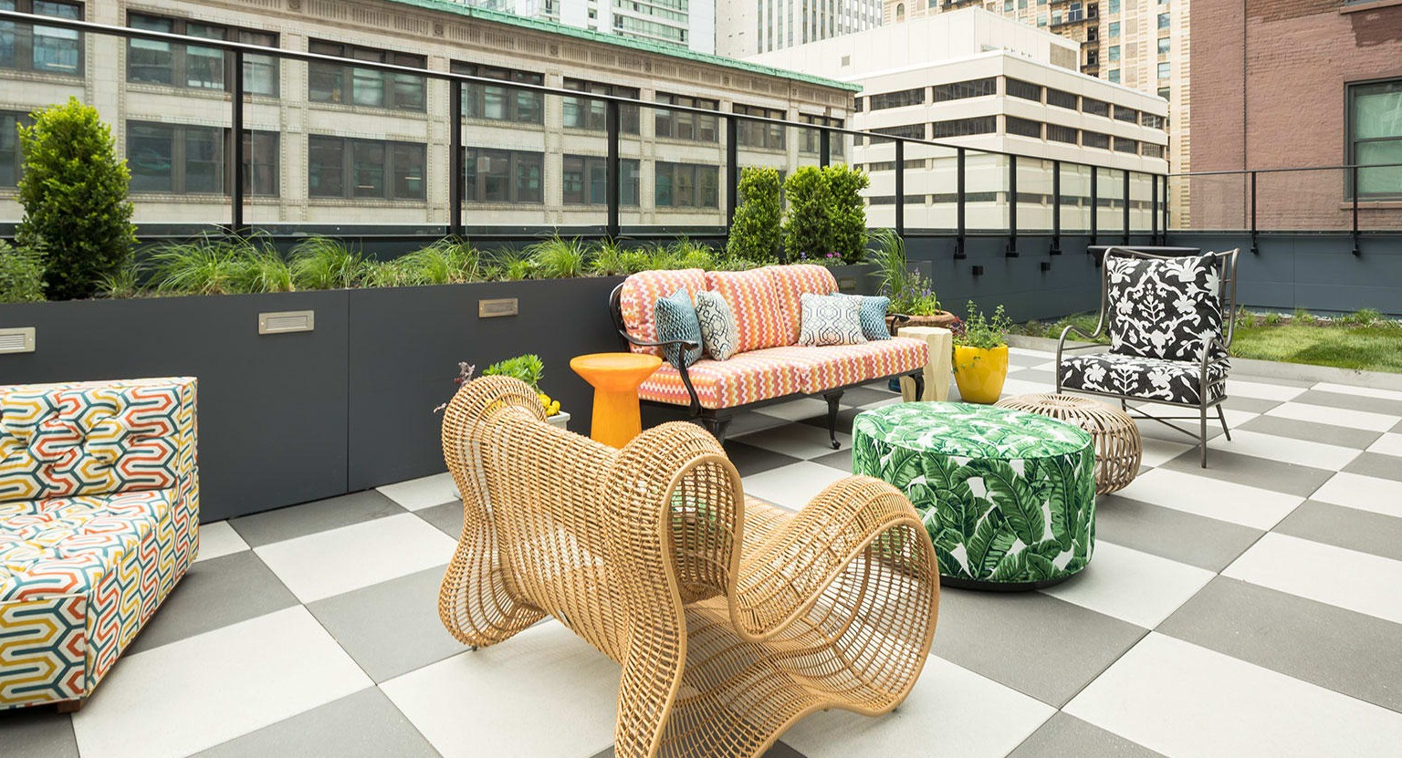 Stylish rooftop terrace with patterned seating and modern furniture, offering city views at MDA Apartments in Chicago