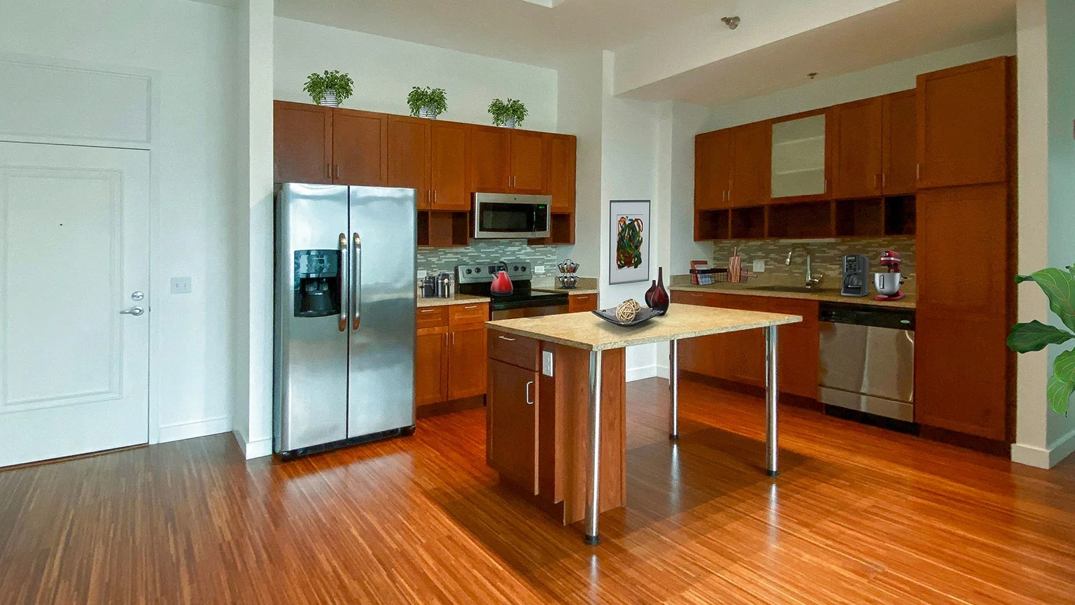 Expansive kitchen with wood cabinets, stainless steel appliances, a center island, and gleaming hardwood floors at MDA Apartments in Chicago