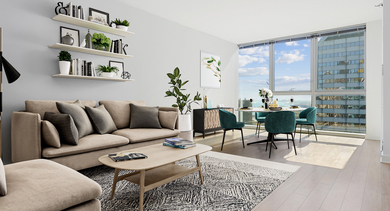 Bright open-concept living and dining area with modern furniture, a large window, and light wood floors at MILA Luxury Apartments in Chicago