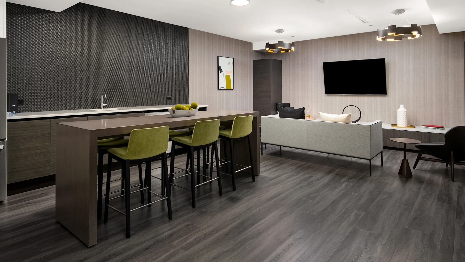 Modern clubroom with a full kitchen, island seating, and a comfortable lounge area with a TV at Millennium on LaSalle in Chicago