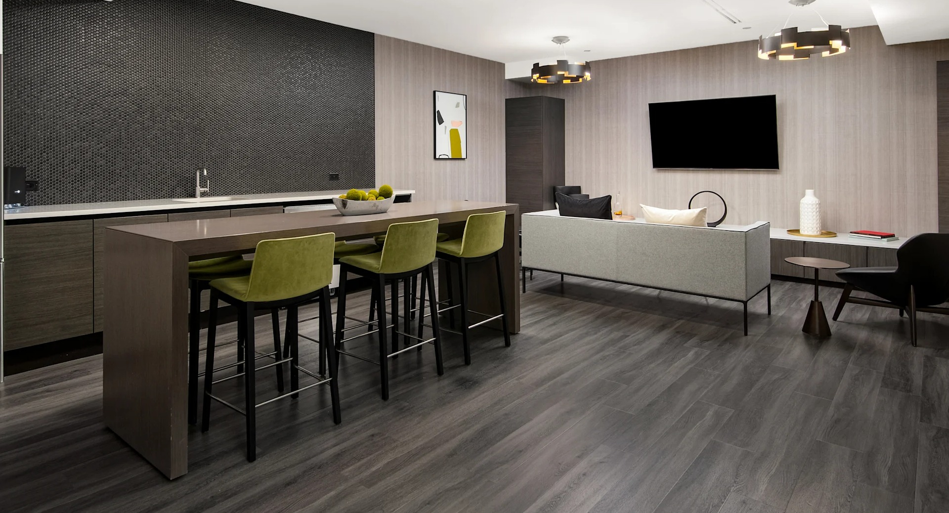 Modern clubroom with a full kitchen, island seating, and a comfortable lounge area with a TV at Millennium on LaSalle in Chicago