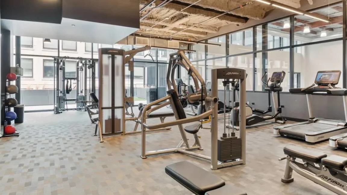 Modern fitness center equipped with various cardio machines, weight equipment, and a dedicated workout area at Millennium on LaSalle in Chicago