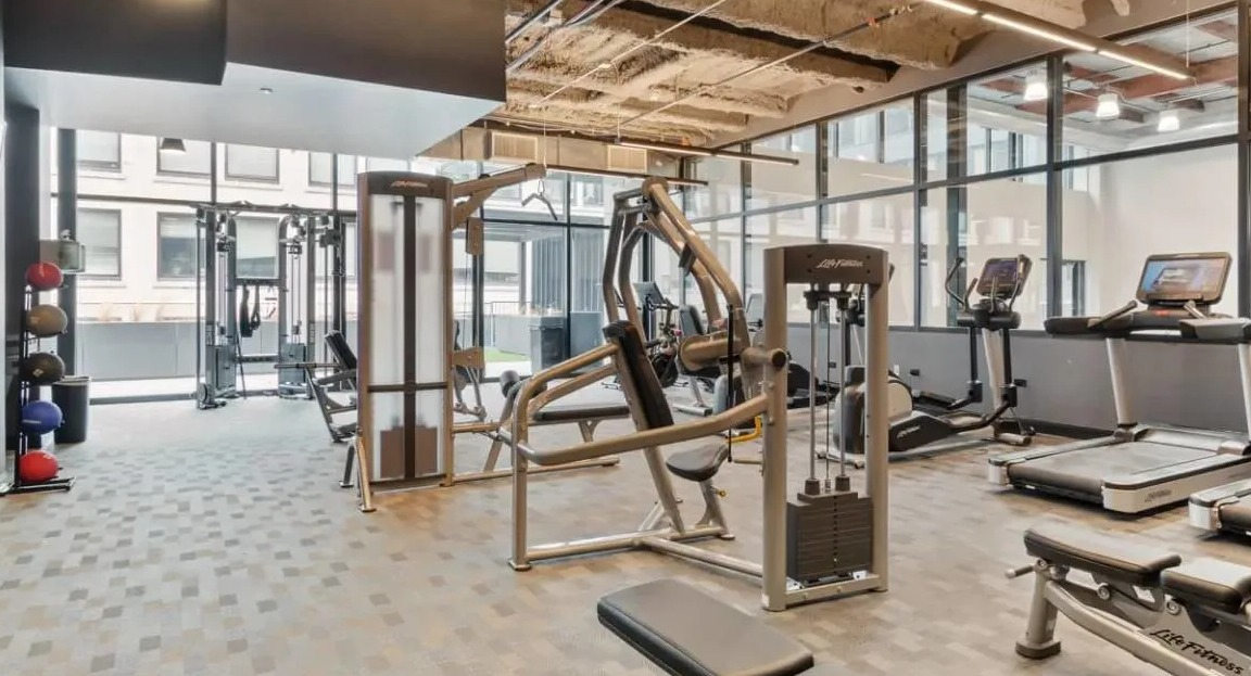 Modern fitness center equipped with various cardio machines, weight equipment, and a dedicated workout area at Millennium on LaSalle in Chicago