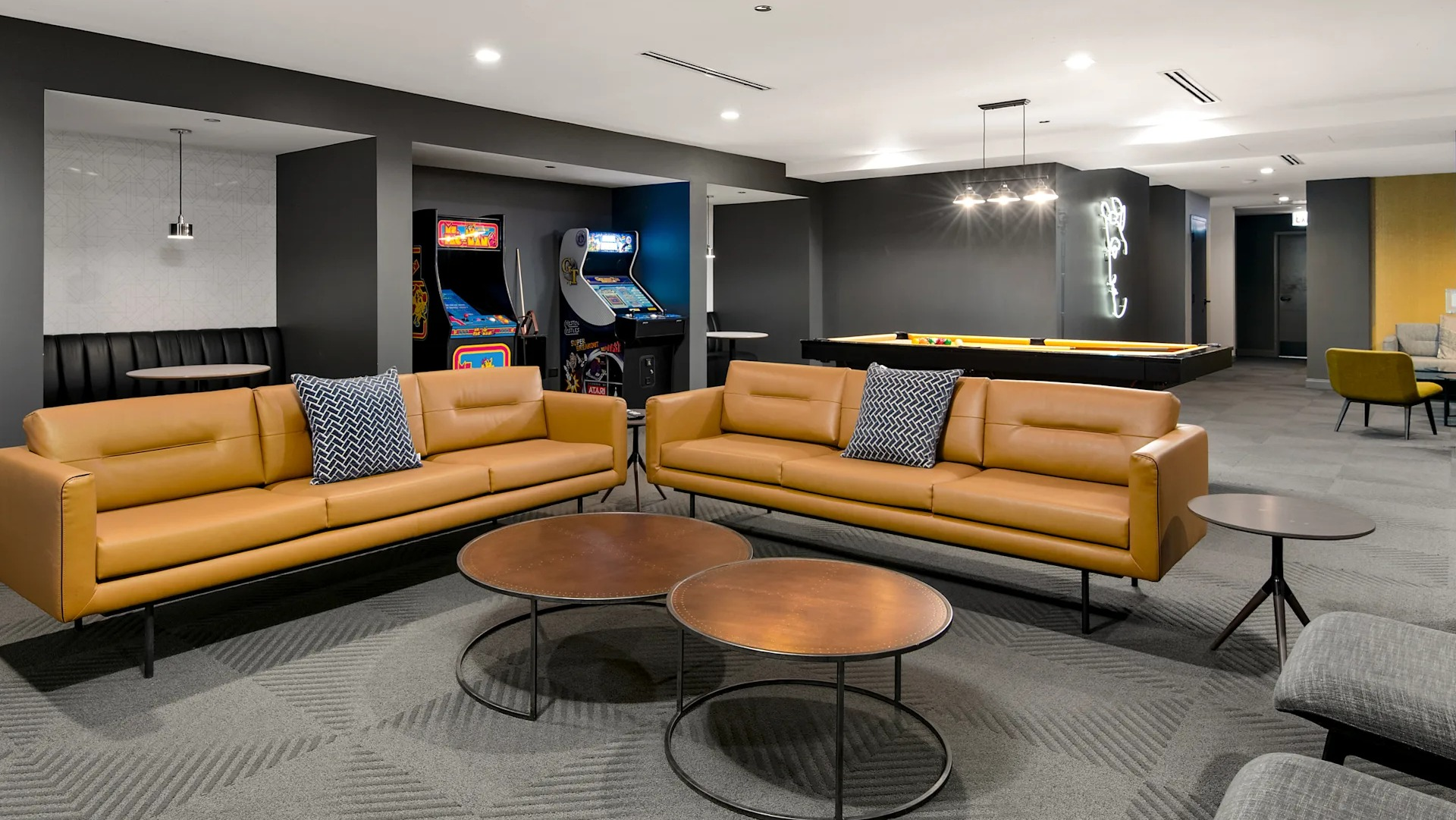 Fun-filled game room featuring arcade machines, comfortable seating, and a billiards table at Millennium on LaSalle in Chicago