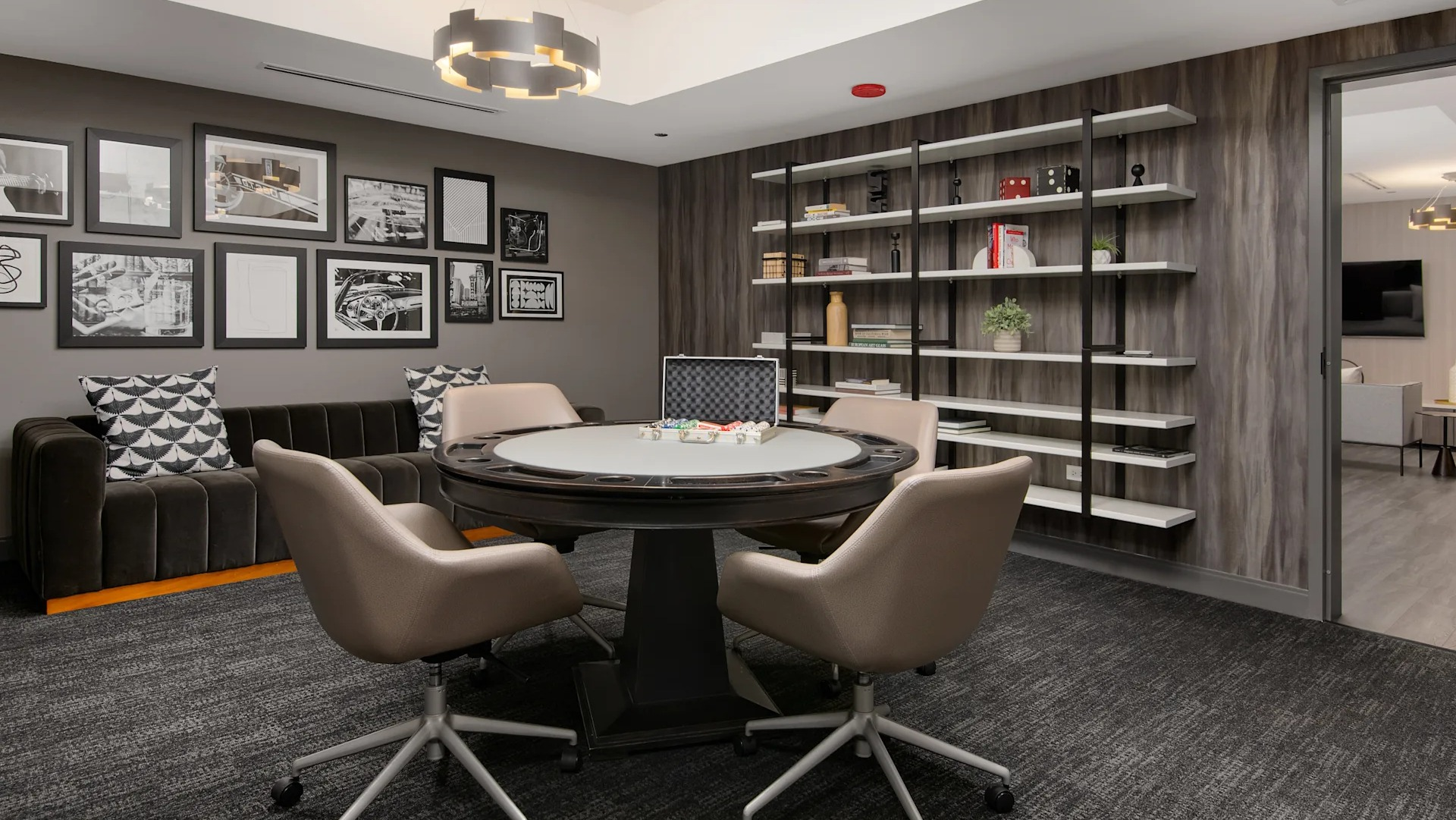 Inviting game room and lounge with a card table, comfortable seating, and shelves filled with books and decor at Millennium on LaSalle in Chicago