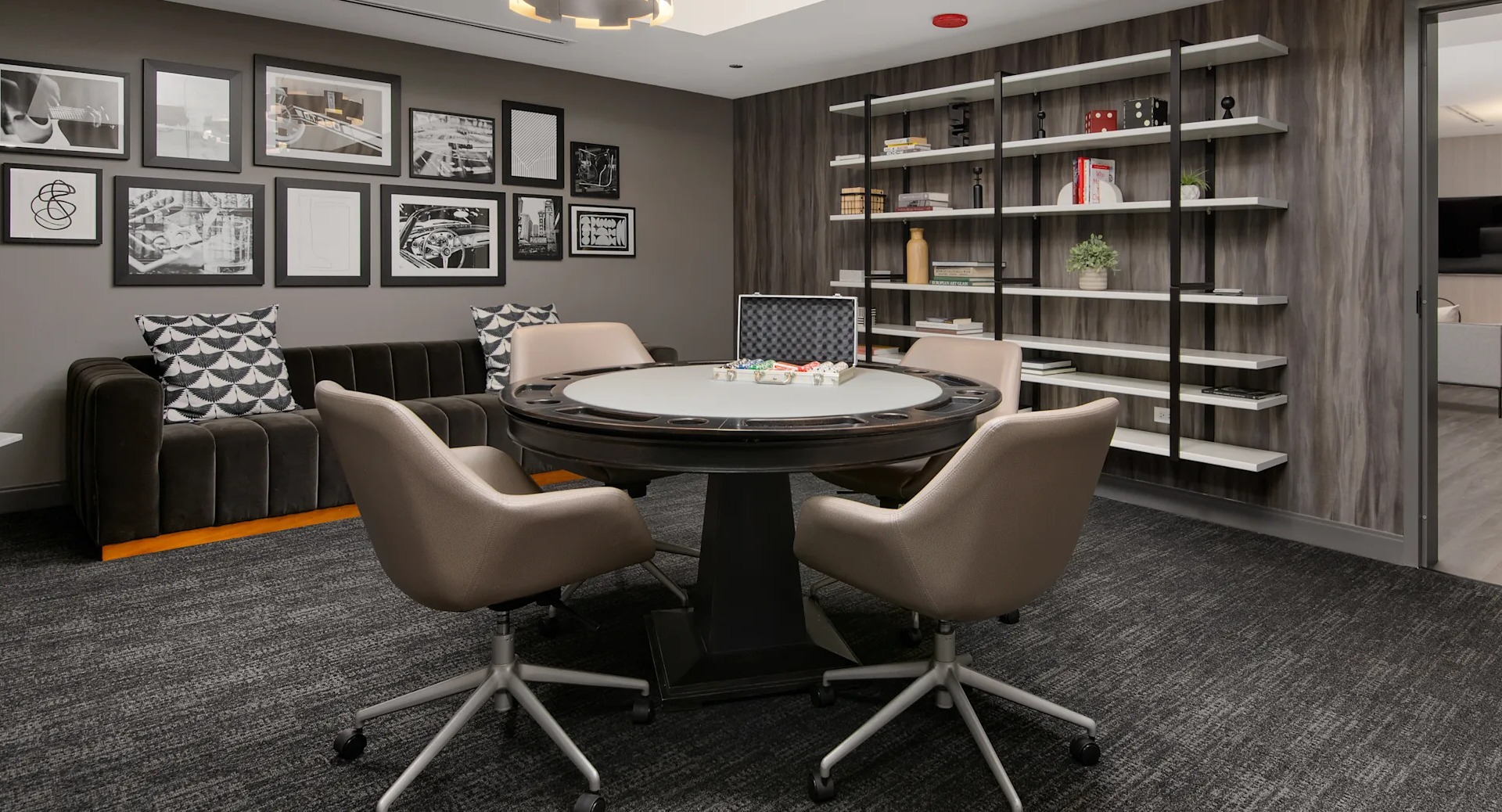 Inviting game room and lounge with a card table, comfortable seating, and shelves filled with books and decor at Millennium on LaSalle in Chicago