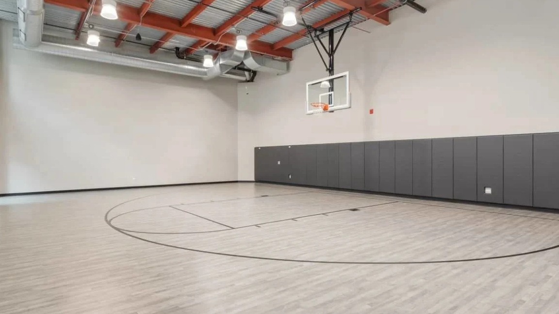 Spacious indoor basketball court with high ceilings and padded walls, perfect for recreation at Millennium on LaSalle in Chicago