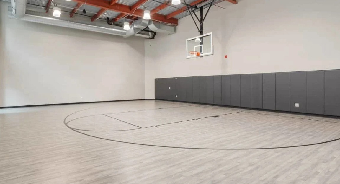 Spacious indoor basketball court with high ceilings and padded walls, perfect for recreation at Millennium on LaSalle in Chicago