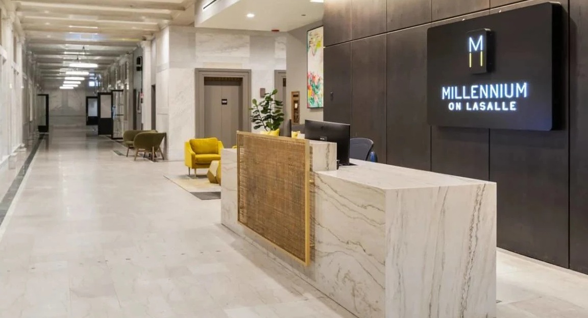 Elegant lobby with a modern reception desk, stylish lighting, and a long hallway leading to elevators at Millennium on LaSalle in Chicago
