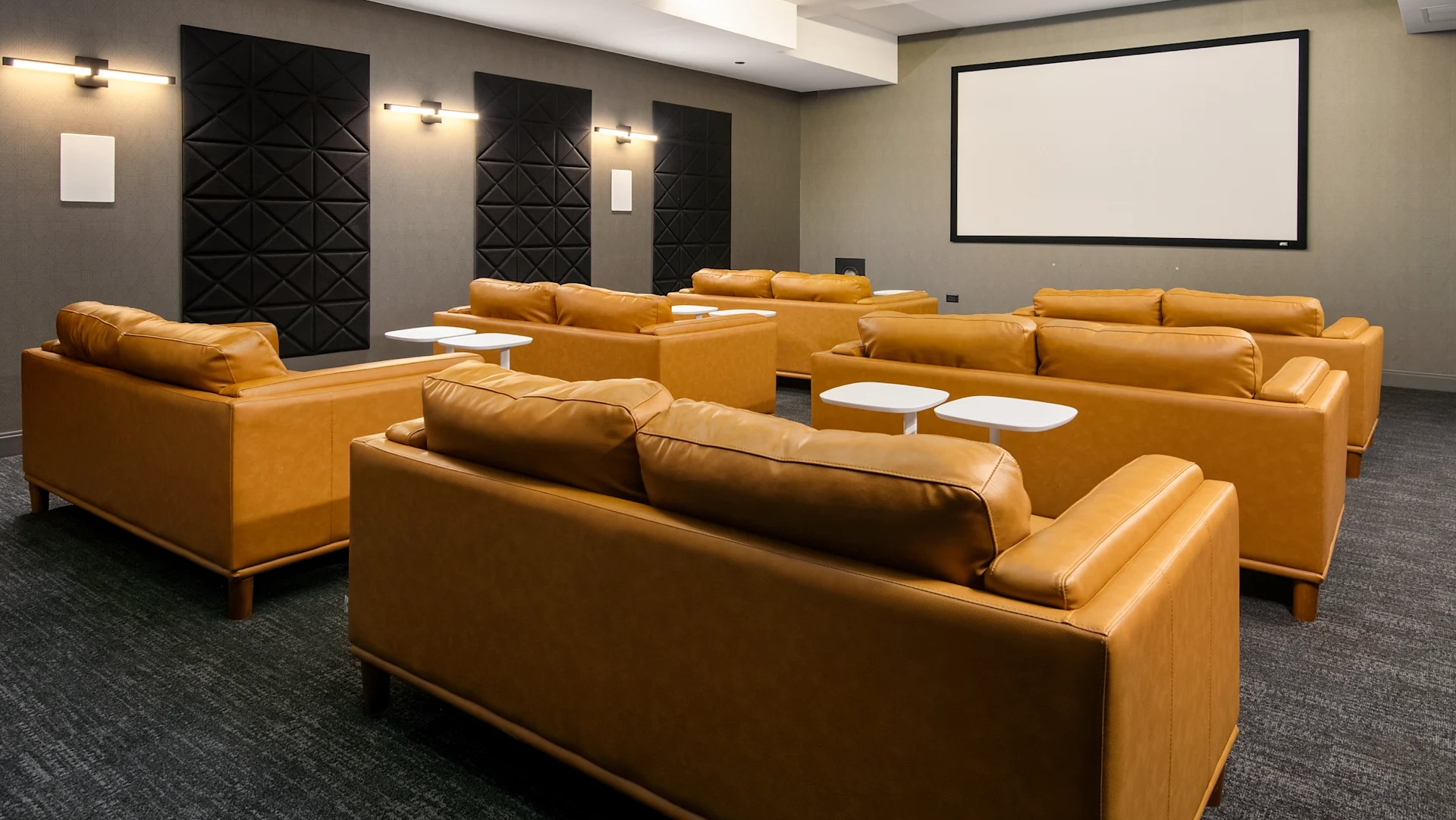 Luxurious private screening room with comfortable brown leather sofas and a large projection screen at Millennium on LaSalle in Chicago