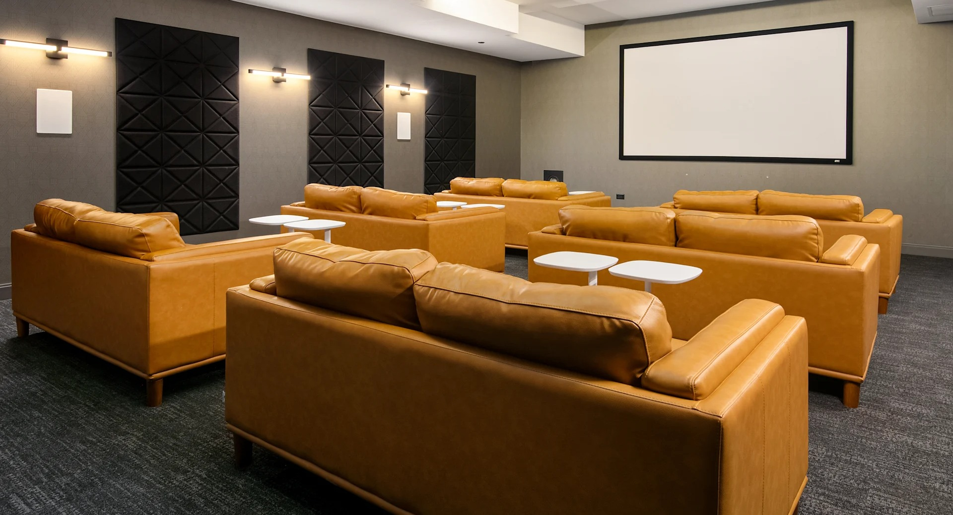Luxurious private screening room with comfortable brown leather sofas and a large projection screen at Millennium on LaSalle in Chicago