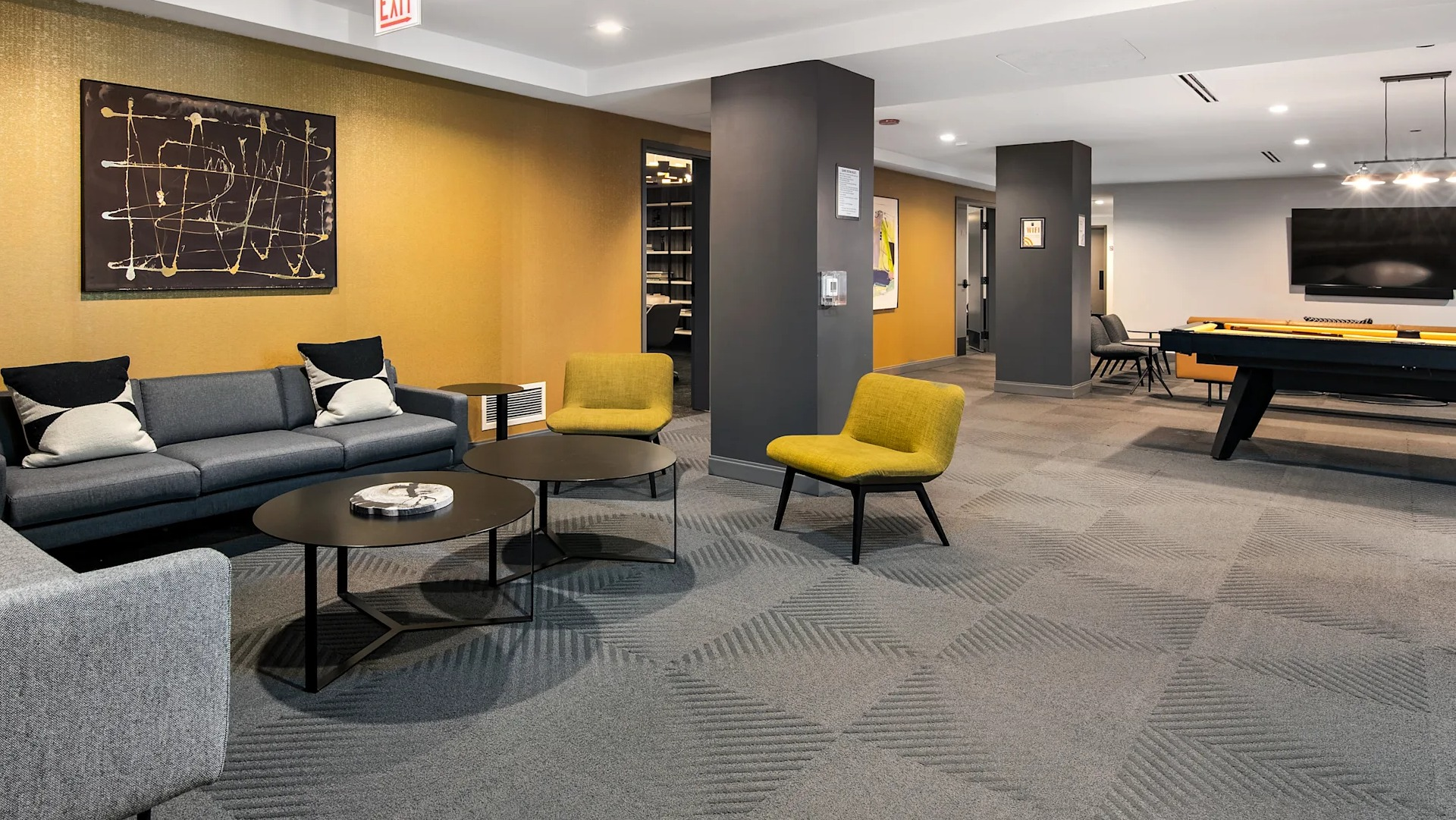 Modern resident lounge with cozy sofas, bright chairs, a pool table, and unique art at Millennium on LaSalle in Chicago