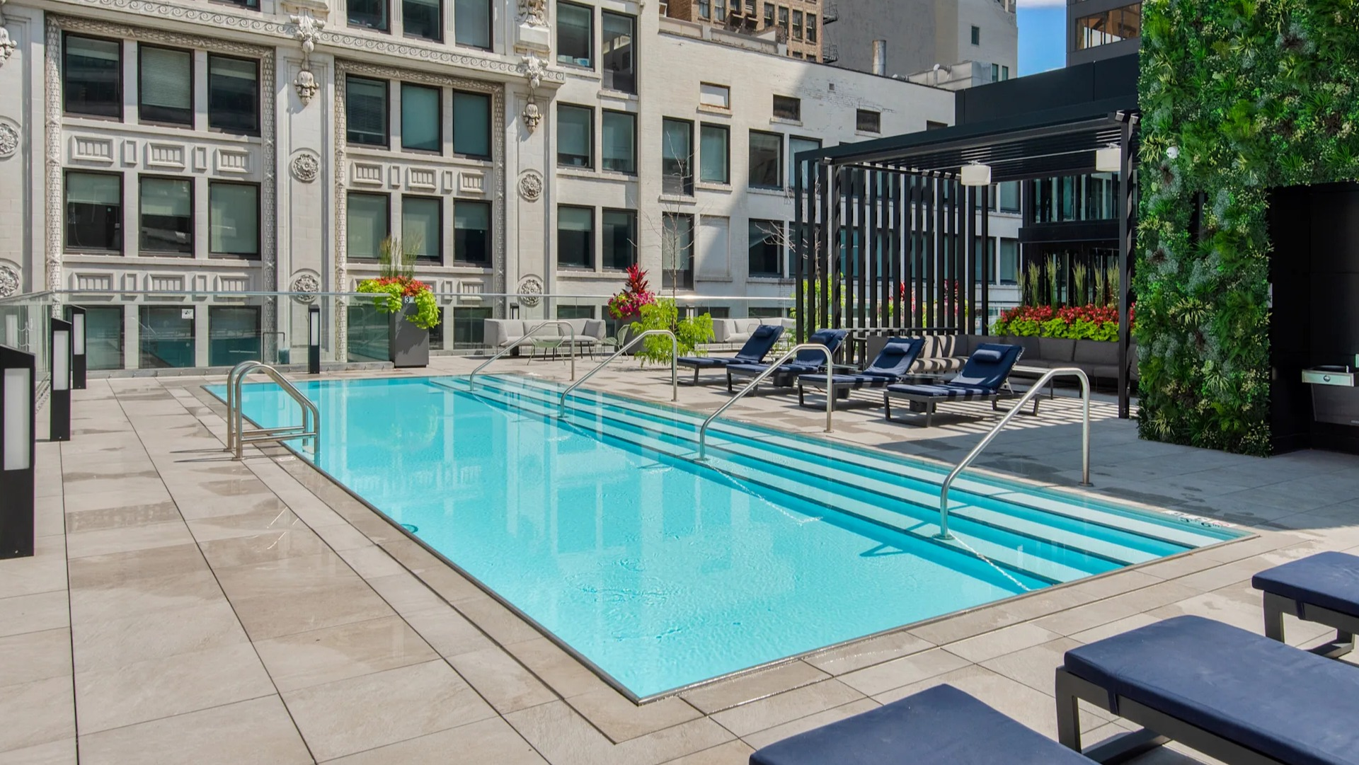 Elevated view of the rooftop swimming pool with lounge seating and historic Chicago architecture at Millennium on LaSalle