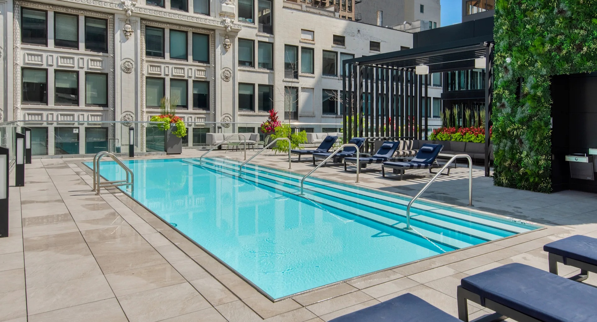 Elevated view of the rooftop swimming pool with lounge seating and historic Chicago architecture at Millennium on LaSalle