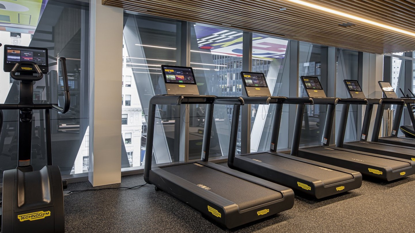 State-of-the-art fitness center with a row of modern treadmills and city views at Millie on Michigan in Chicago