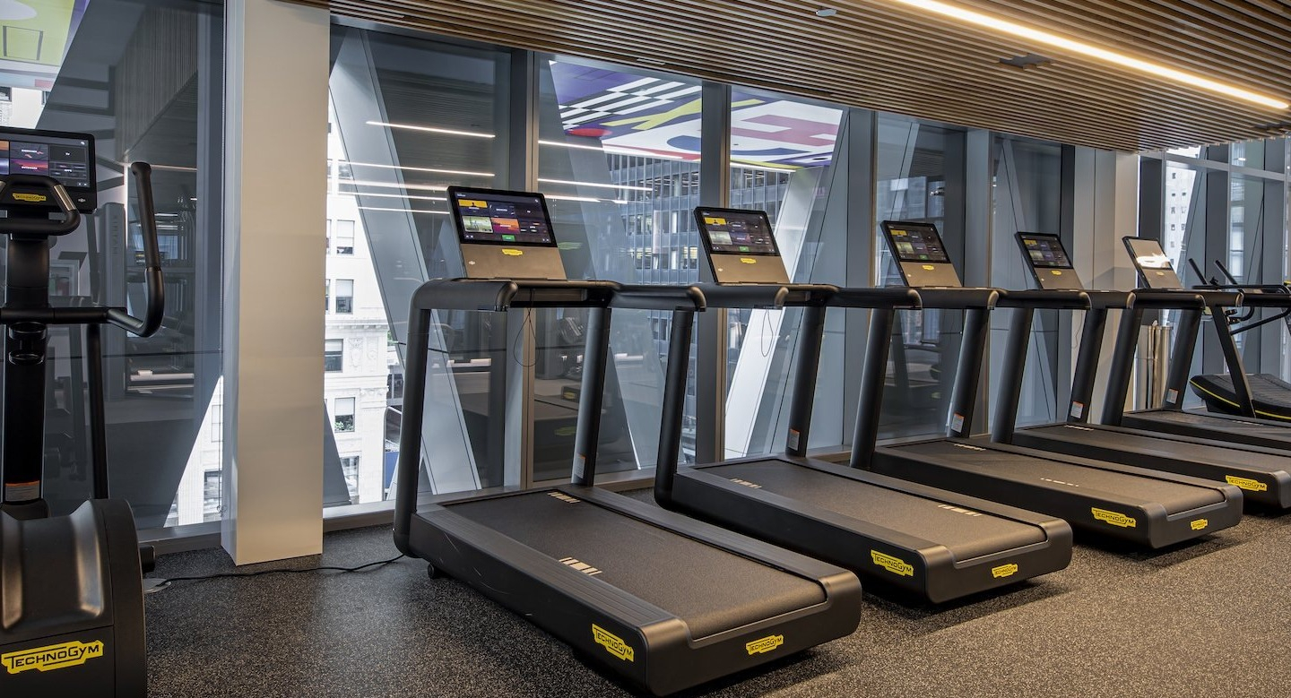 State-of-the-art fitness center with a row of modern treadmills and city views at Millie on Michigan in Chicago