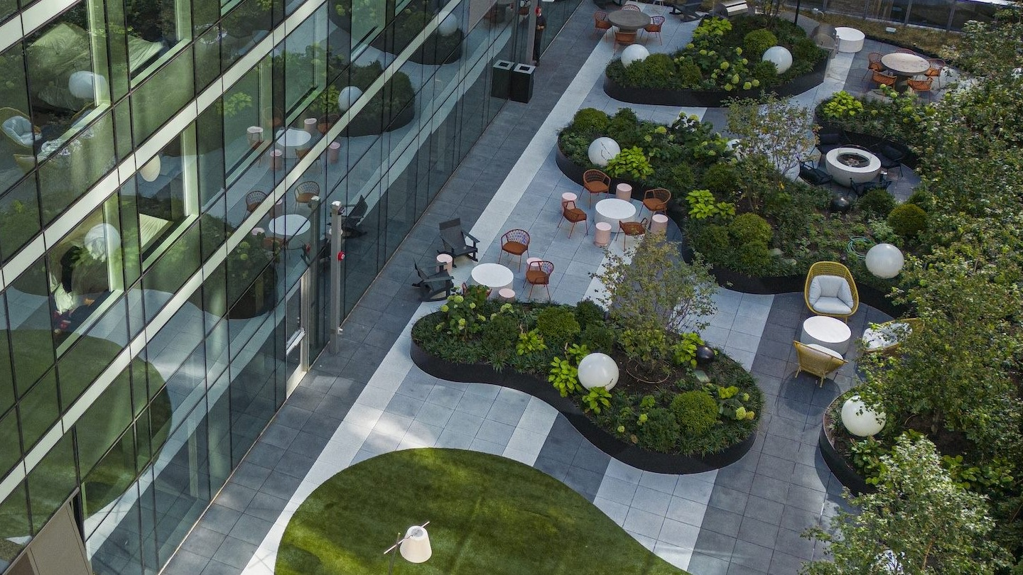 Lush green terrace lounge area with various seating options and natural landscaping, offering a serene escape at Millie on Michigan Chicago