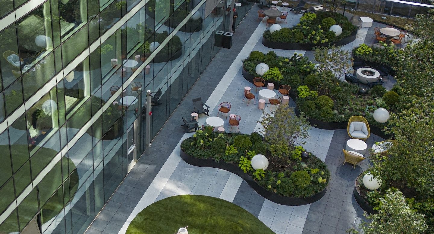 Lush green terrace lounge area with various seating options and natural landscaping, offering a serene escape at Millie on Michigan Chicago