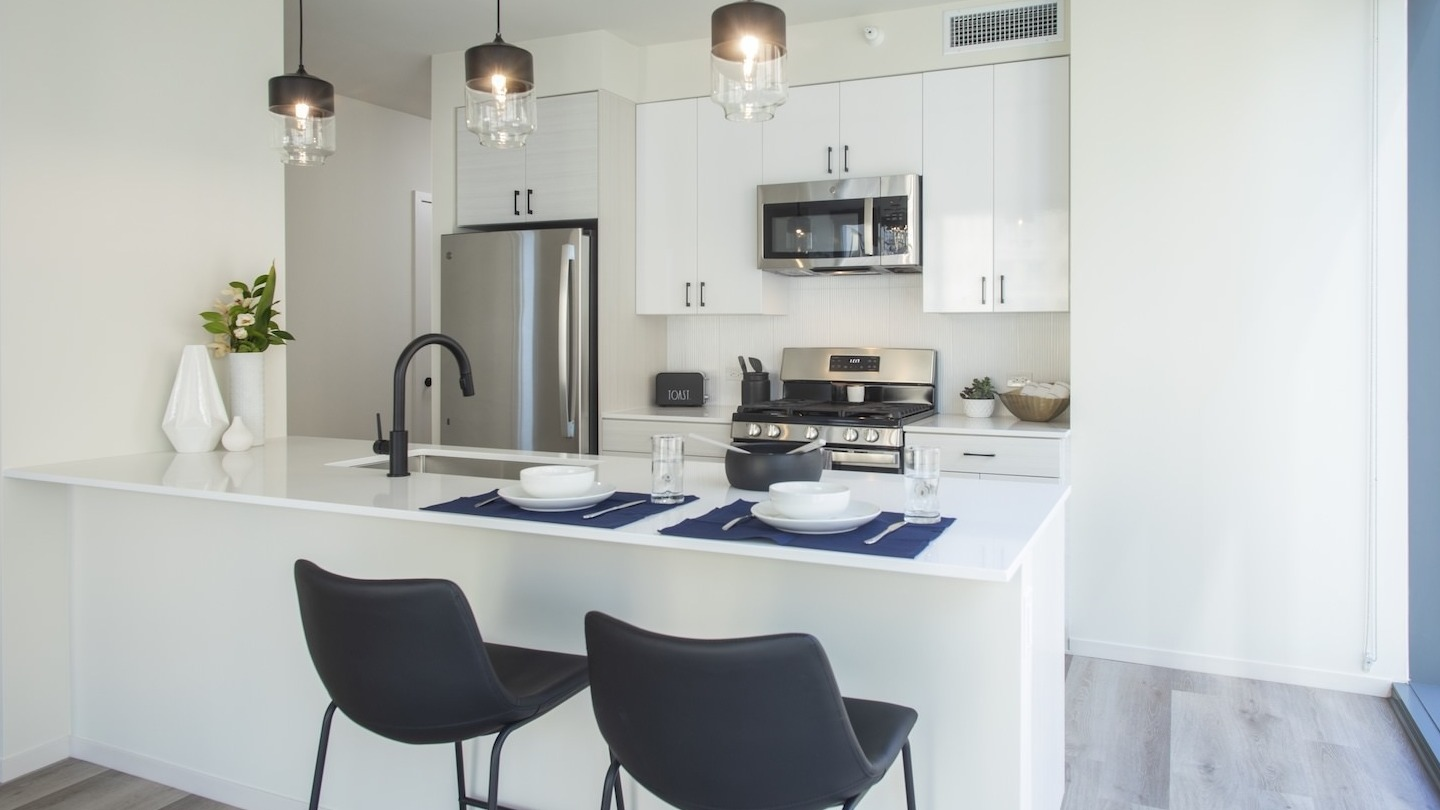 Spacious open-concept kitchen and living area with large windows at Millie on Michigan apartments in Chicago