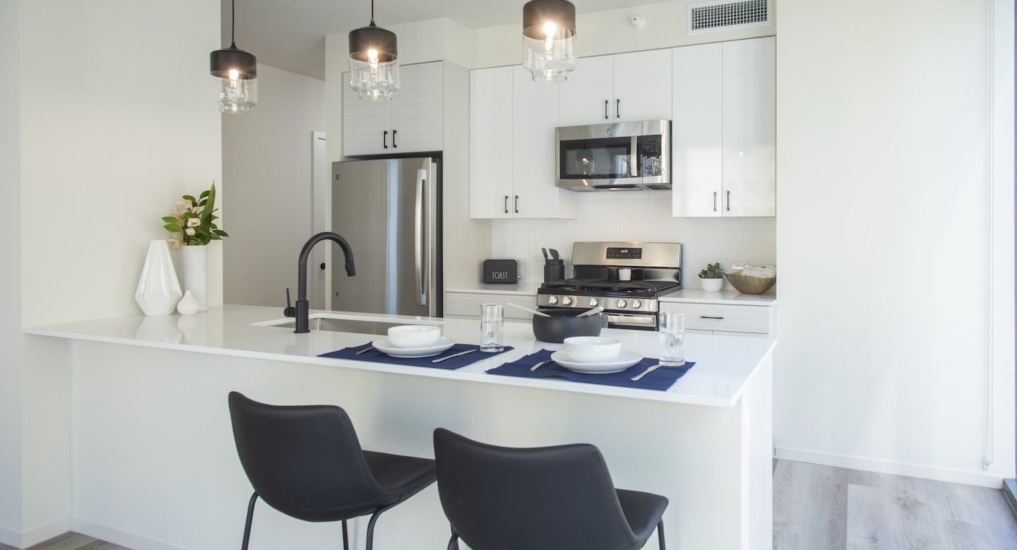 Spacious open-concept kitchen and living area with large windows at Millie on Michigan apartments in Chicago