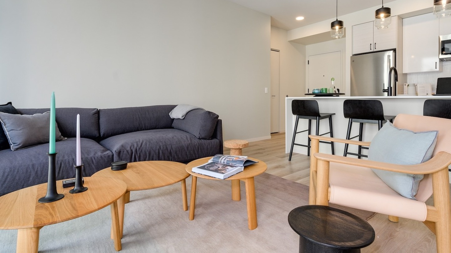 Open-concept living room with a spacious sofa, stylish coffee tables, and a modern kitchen at Millie on Michigan Chicago