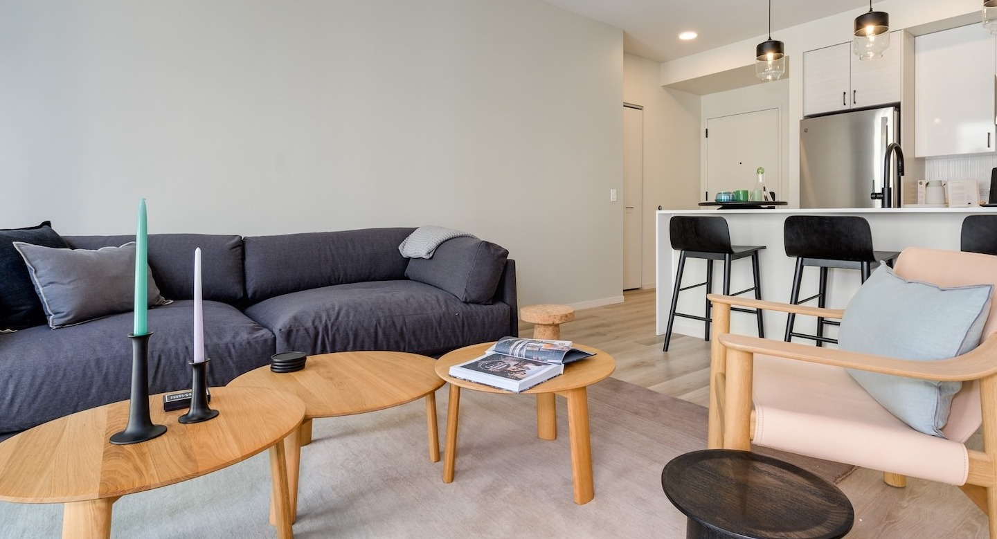 Open-concept living room with a spacious sofa, stylish coffee tables, and a modern kitchen at Millie on Michigan Chicago