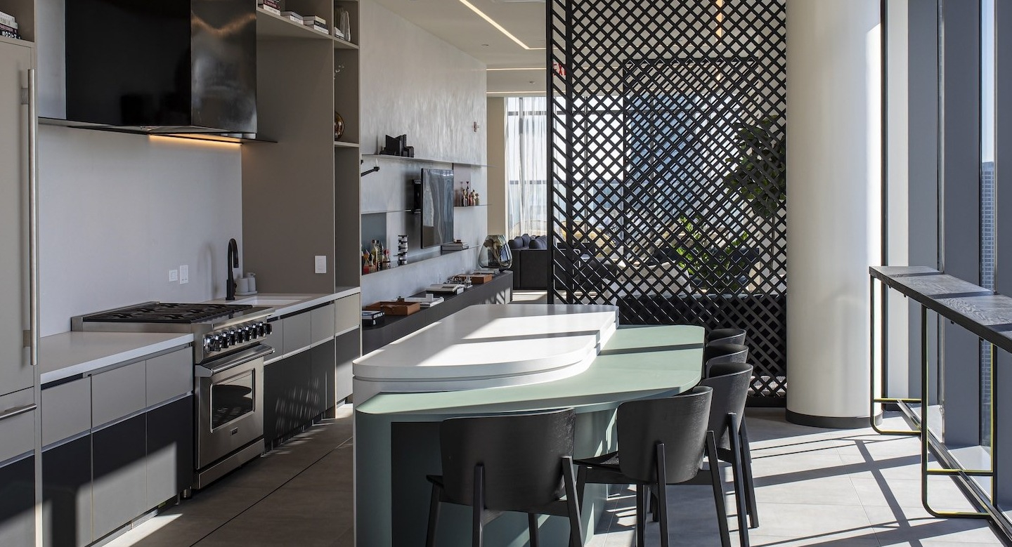 Modern resident lounge kitchen and bar area with tall windows at Millie on Michigan apartments in Chicago