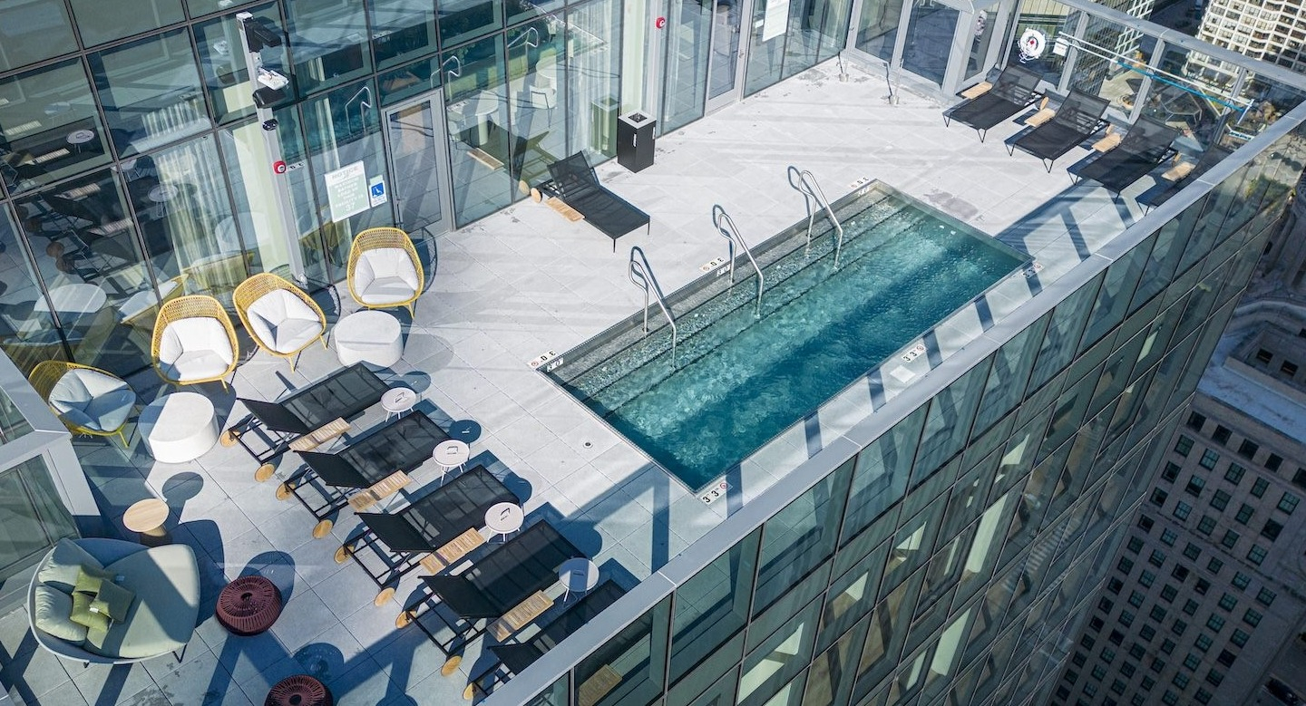 Stunning rooftop pool deck with lounge chairs and breathtaking city skyline views at Millie on Michigan Chicago