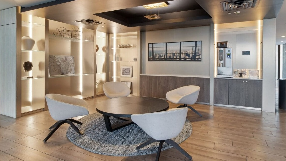 An elegant seating nook with modern chairs, a round table, and artistic decor at Moment Apartments in Chicago