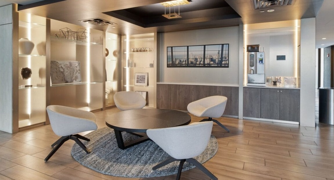 An elegant seating nook with modern chairs, a round table, and artistic decor at Moment Apartments in Chicago
